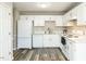 Well-lit kitchen with white cabinetry, appliances, and flooring at 519 Touchstone Dr, Durham, NC 27713