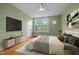 Cozy bedroom with modern ceiling fan, large window, and stylish furniture set against an inviting green color scheme at 524 S Boylan Ave, Raleigh, NC 27603