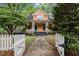 Inviting home featuring a stone path leading through a white picket fence to a charming, covered front porch at 524 S Boylan Ave, Raleigh, NC 27603