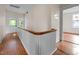 Bright hallway featuring wood floors, white walls, and a staircase with a wooden handrail leading to the upper level at 524 S Boylan Ave, Raleigh, NC 27603