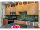 Modern kitchen with stainless steel appliances, green backsplash, and light wood cabinets at 524 S Boylan Ave, Raleigh, NC 27603
