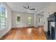 Bright living room with hardwood floors, fireplace, fan, and large windows overlooking the lawn at 524 S Boylan Ave, Raleigh, NC 27603