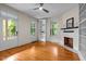 Bright living room featuring hardwood floors, fireplace, built-in shelving, ceiling fan, and plenty of natural light at 524 S Boylan Ave, Raleigh, NC 27603