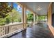 Expansive front porch features sleek dark flooring and white columns, perfect for relaxing and enjoying the neighborhood view at 524 S Boylan Ave, Raleigh, NC 27603