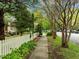 A peaceful street view with mature trees lining the sidewalk and a white picket fence at 524 S Boylan Ave, Raleigh, NC 27603