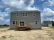Rear exterior showing the back of the house, windows, and a small wooden deck at 54 Grove Township Way, Angier, NC 27501