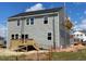 Backyard view of gray siding and wooden deck, awaiting landscaping at 54 Grove Township Way, Angier, NC 27501