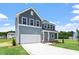 Beautifully landscaped two-story home with gray siding, a spacious garage, and a manicured lawn at 54 Grove Township Way, Angier, NC 27501