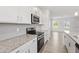 Well-lit kitchen showcases stainless steel appliances, gray backsplash, and granite counters with stylish cabinetry at 54 Grove Township Way, Angier, NC 27501