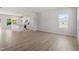 Spacious living room featuring light wood floors and plenty of natural light, leading into the kitchen at 54 Grove Township Way, Angier, NC 27501