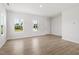 Well-lit living area with light wood floors, white walls, and bright windows, next to the entryway at 54 Grove Township Way, Angier, NC 27501
