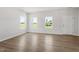 Bright living area with light wood flooring, white walls, and large windows overlooking the green lawn at 54 Grove Township Way, Angier, NC 27501