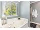 Bathroom with a large bathtub, a window, and a separate shower at 5413 Botany Bay Dr, Raleigh, NC 27616