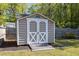 Backyard shed with a wooden ramp, double doors, and neutral siding at 5413 Botany Bay Dr, Raleigh, NC 27616