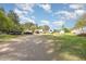 Gravel driveway leading to a spacious backyard with multiple outbuildings and vehicles at 545 Billy Fitts Rd, Siler City, NC 27344