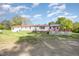 Backyard view featuring white siding, brick foundation, a spacious yard and a red metal roof at 545 Billy Fitts Rd, Siler City, NC 27344