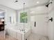 Modern bathroom featuring a soaking tub and a sleek, glass-enclosed shower at 5708 Butter Churn Way, Fuquay Varina, NC 27526