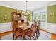 Elegant dining room with green walls, wainscoting, chandelier and a large window with shutters at 5708 Butter Churn Way, Fuquay Varina, NC 27526