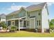 Rear exterior view of the home featuring a screened-in porch and lush lawn at 5708 Butter Churn Way, Fuquay Varina, NC 27526