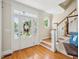 Bright foyer with hardwood floors, a staircase, and a view of the front door with sidelights at 5708 Butter Churn Way, Fuquay Varina, NC 27526