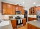 Well-equipped kitchen features granite countertops, stainless appliances, and wooden cabinetry at 5708 Butter Churn Way, Fuquay Varina, NC 27526
