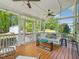 Cozy screened-in porch featuring a swing bed, wood floors, and a view of the lush backyard at 5708 Butter Churn Way, Fuquay Varina, NC 27526
