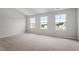 Bedroom featuring three windows allowing ample natural light and plush neutral carpet at 59 Grove Township Way, Angier, NC 27501