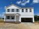 Charming two-story home with a welcoming front porch and an attached two-car garage at 59 Grove Township Way, Angier, NC 27501