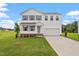 Charming two-story home with a well-manicured lawn, attached two-car garage, and classic architectural details at 59 Grove Township Way, Angier, NC 27501