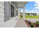 Inviting front porch with white columns, brick accents, and lush landscaping creating a welcoming entrance at 59 Grove Township Way, Angier, NC 27501