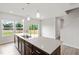 Open kitchen with large island, stainless steel appliances, and a view to the outdoor deck at 59 Grove Township Way, Angier, NC 27501