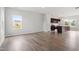 Open-concept living room featuring wood flooring, natural light, and seamless flow to the modern kitchen area at 59 Grove Township Way, Angier, NC 27501