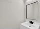 Bathroom vanity with white countertop, black faucet, and a modern mirror at 6101 Clarks Fork Dr, Raleigh, NC 27616