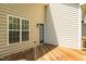 The deck has a door into the house and windows provide a glimpse of the green backyard at 6101 Clarks Fork Dr, Raleigh, NC 27616