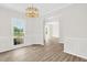Elegant dining room with wood floors, decorative chandelier, wainscoting, and arched doorway at 6101 Clarks Fork Dr, Raleigh, NC 27616