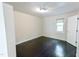 This is a bright bedroom with wood floors and a large window letting in natural light, and a closed door at 6409 Lakeland Dr, Raleigh, NC 27612