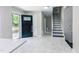 Open entryway with white tile flooring, black front door and staircase leading upstairs at 6409 Lakeland Dr, Raleigh, NC 27612