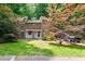 Modern stone-faced home with a well-manicured lawn and mature trees at 6409 Lakeland Dr, Raleigh, NC 27612