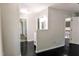Hallway leading to a bathroom, featuring dark wood floors and neutral walls, with natural light coming through windows at 6409 Lakeland Dr, Raleigh, NC 27612