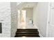 Hallway view with stone accent wall leading to stairs and bathroom at 6409 Lakeland Dr, Raleigh, NC 27612
