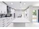 Beautiful white kitchen with a large island, modern lighting, and black appliances at 6409 Lakeland Dr, Raleigh, NC 27612