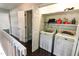 This image shows a laundry area with a washer and dryer, shelving above, and a closet area nearby at 6409 Lakeland Dr, Raleigh, NC 27612