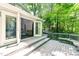 A gray wooden patio with an open door gives a view of the home's cozy interior and lush backyard at 6409 Lakeland Dr, Raleigh, NC 27612