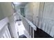 This shows the staircase with white railings, white walls, and dark wood floors at the bottom of the stairs at 6409 Lakeland Dr, Raleigh, NC 27612