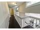 This is a well-lit staircase and landing with white railings and dark wood floors and leads to a room downstairs at 6409 Lakeland Dr, Raleigh, NC 27612