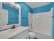 Cheerful bathroom with a white vanity, framed mirror, blue walls, and a shower-tub combination at 709 Basil Dr, Durham, NC 27713