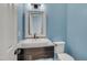 Stylish bathroom featuring a decorative mirror, unique sink, and blue walls at 709 Basil Dr, Durham, NC 27713