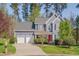 Two-story home featuring a red front door, well-manicured lawn and a two-car garage at 709 Basil Dr, Durham, NC 27713
