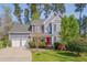 Charming two-story home with a vibrant red door, well-manicured lawn and an attached two-car garage at 709 Basil Dr, Durham, NC 27713