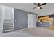 Open-concept living room shows staircase, high ceilings, neutral color palette, ceiling fan, and kitchen access at 709 Basil Dr, Durham, NC 27713